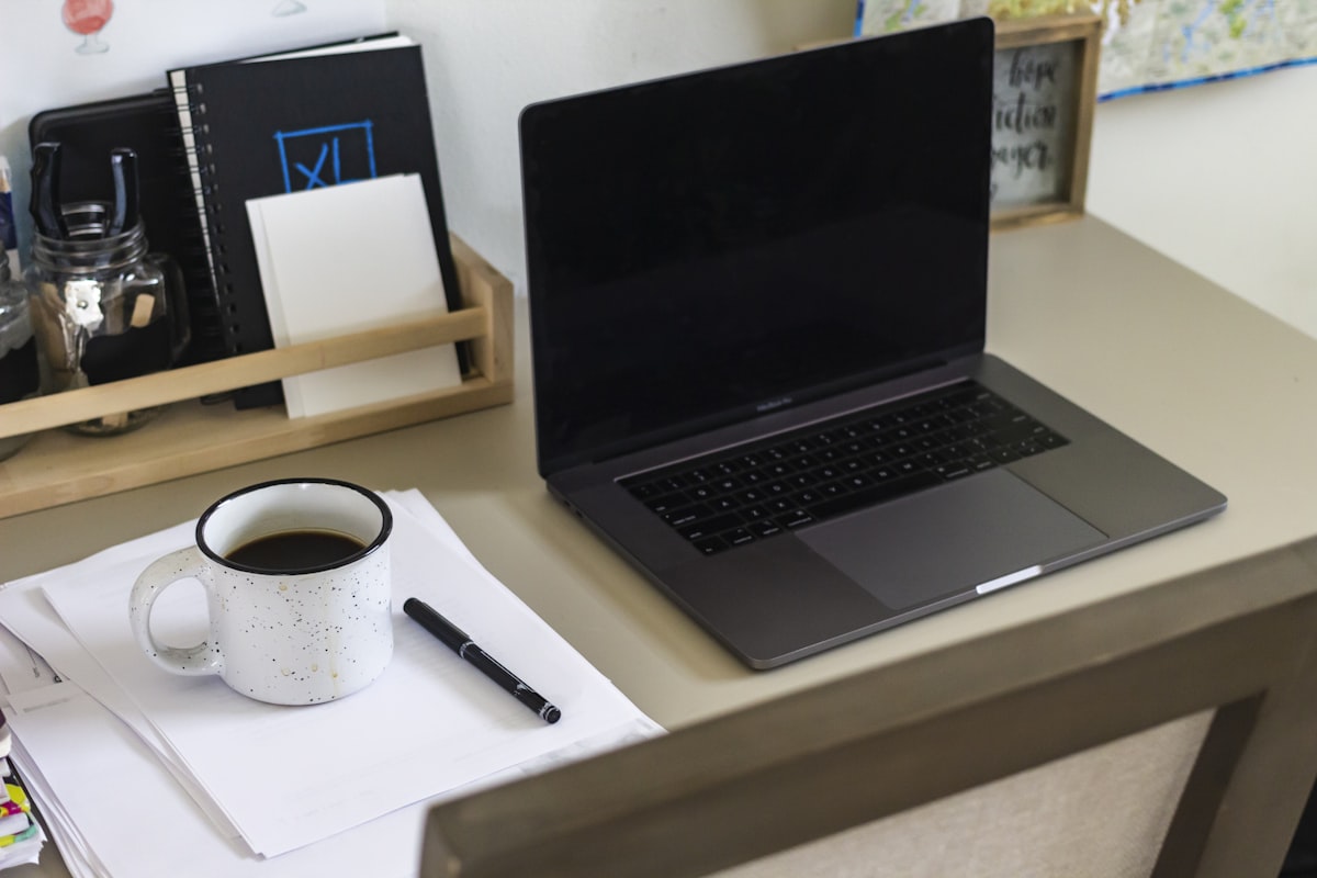 Laptop with coffee mug on clean desk workspace