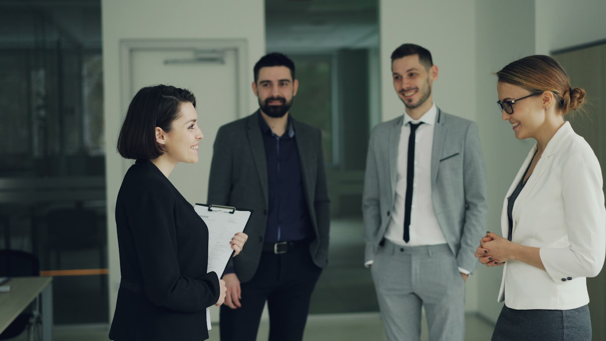 Four professionals in suits discussing in office