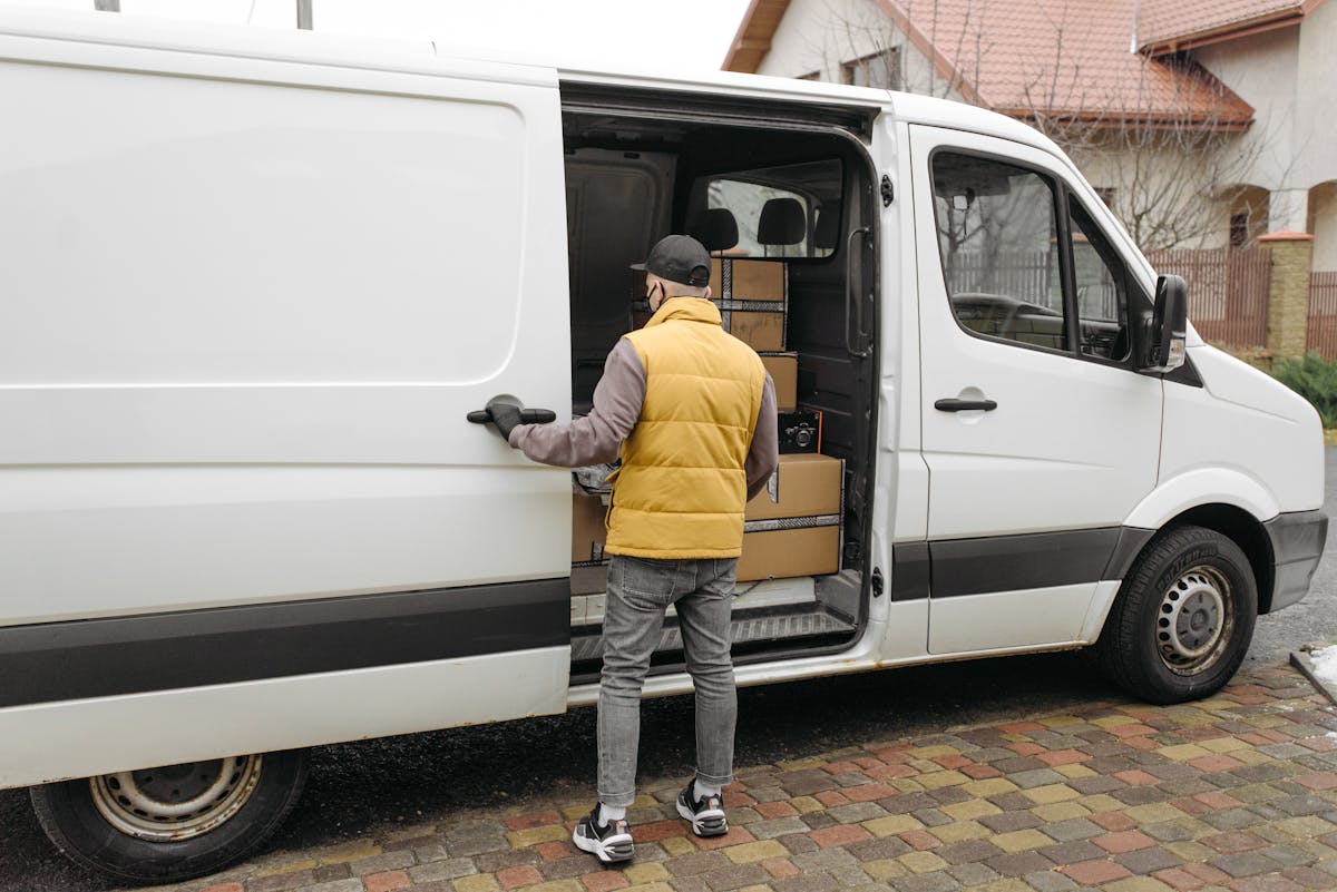 Delivery driver loading packages into a delivery van