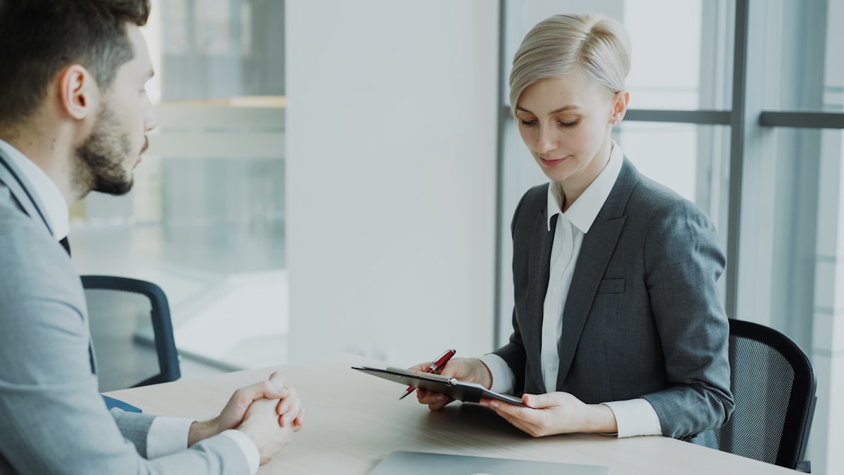 Woman in suit reviewing professional summary with colleague